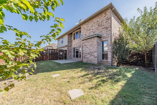 back of house with a yard and a patio area