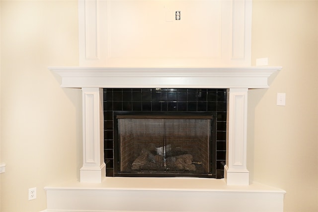 interior details featuring a tiled fireplace