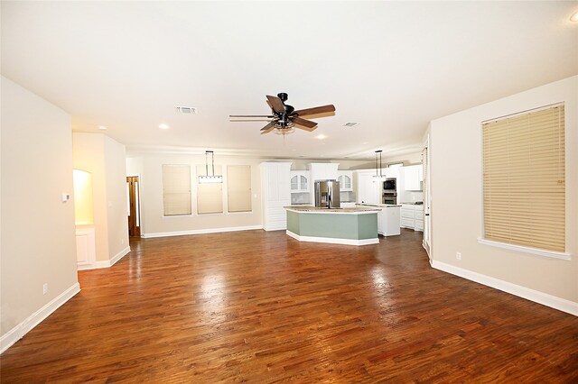 unfurnished living room with ceiling fan and dark hardwood / wood-style floors