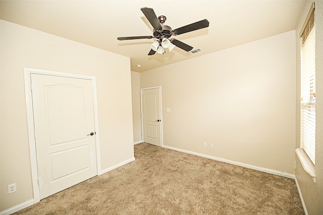 unfurnished bedroom featuring light colored carpet and ceiling fan