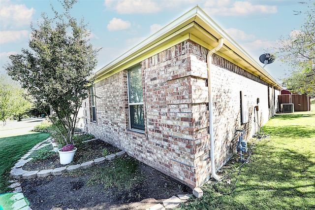 view of side of property with a yard and cooling unit