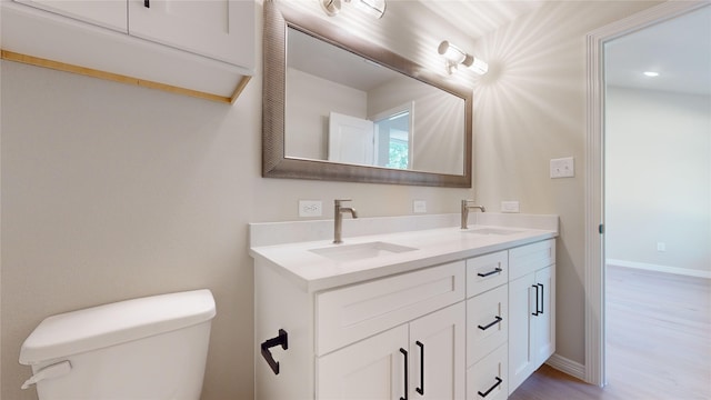 bathroom featuring wood-type flooring, vanity, and toilet