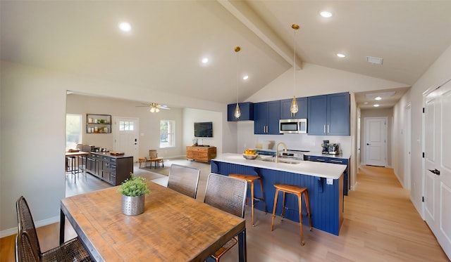 dining room featuring beamed ceiling, sink, ceiling fan, high vaulted ceiling, and light wood-type flooring