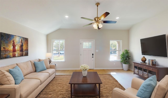 living room featuring light hardwood / wood-style floors, vaulted ceiling, and ceiling fan