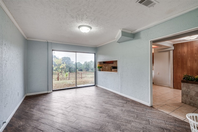 unfurnished room with hardwood / wood-style floors, ornamental molding, and a textured ceiling