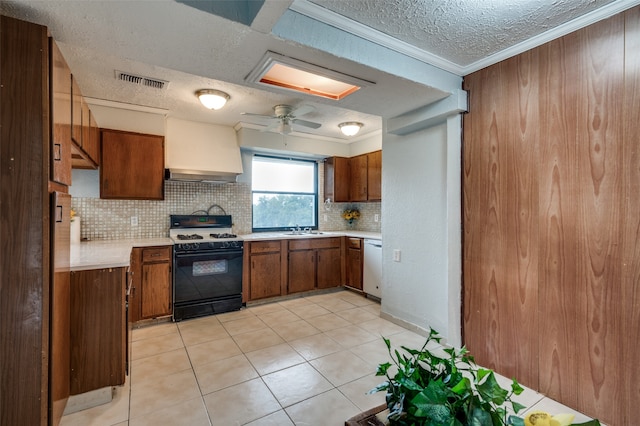 kitchen featuring premium range hood, backsplash, light tile patterned floors, black range with gas stovetop, and ceiling fan