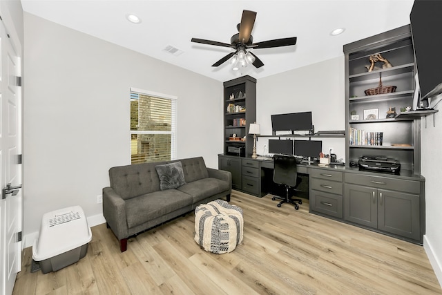 office with light hardwood / wood-style floors, ceiling fan, and built in desk