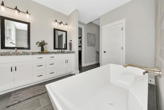 bathroom featuring vanity, tile patterned floors, and a bath