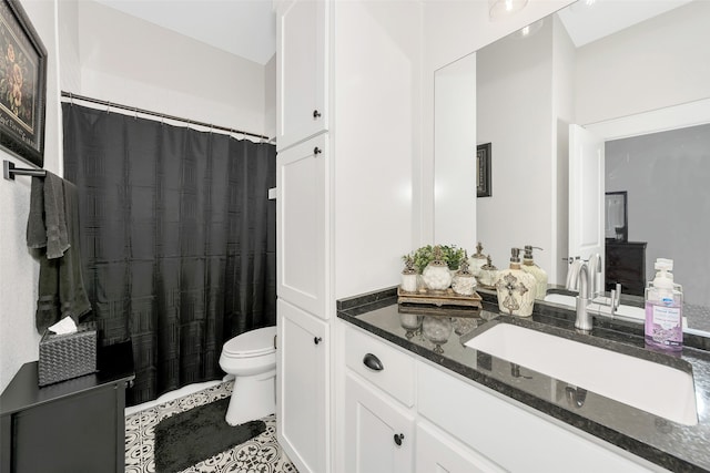 bathroom with toilet, vanity, and tile patterned floors