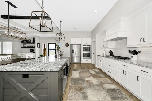 kitchen with pendant lighting, white cabinets, a large island, and stainless steel appliances