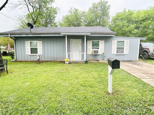 ranch-style house featuring a front yard, cooling unit, and a porch