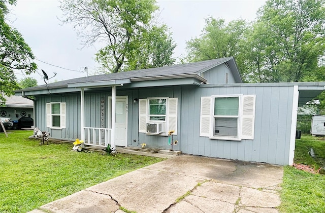 view of front of house with cooling unit, covered porch, and a front yard