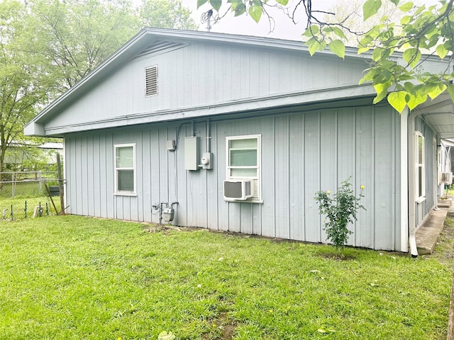 view of side of property featuring cooling unit and a lawn