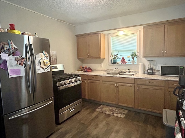 kitchen featuring dark wood-type flooring, a textured ceiling, sink, and stainless steel appliances