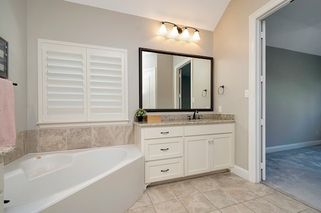 bathroom featuring a tub to relax in, vanity, and vaulted ceiling