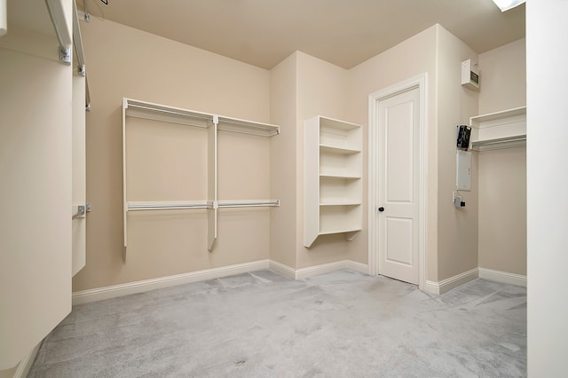 walk in closet featuring light colored carpet