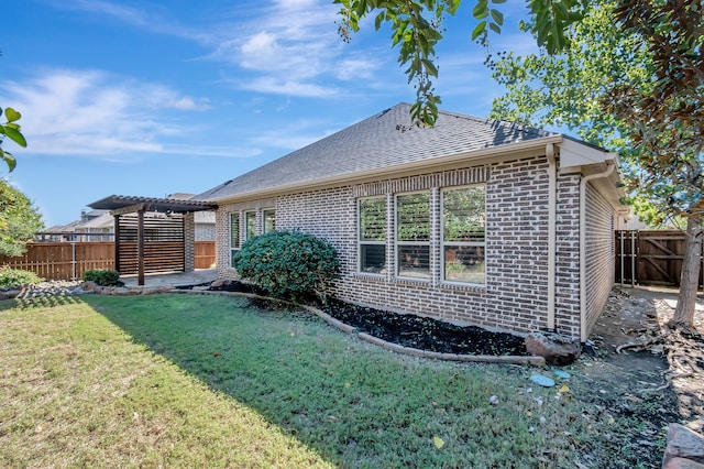 rear view of house with a yard and a pergola