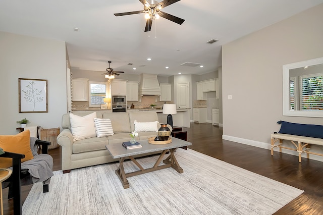 living room featuring ceiling fan and dark hardwood / wood-style floors