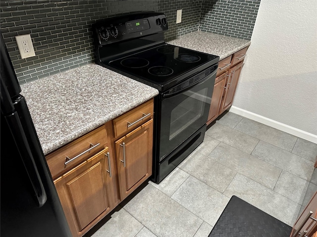 kitchen with tasteful backsplash and black range with electric stovetop