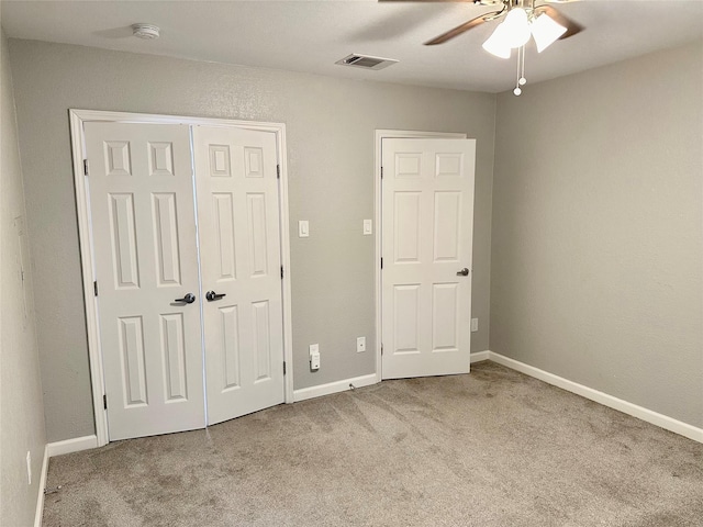 unfurnished bedroom featuring light carpet and ceiling fan