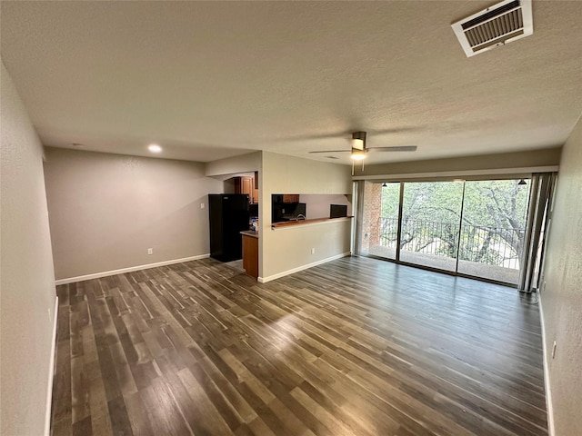 unfurnished living room featuring a textured ceiling, dark hardwood / wood-style floors, and ceiling fan