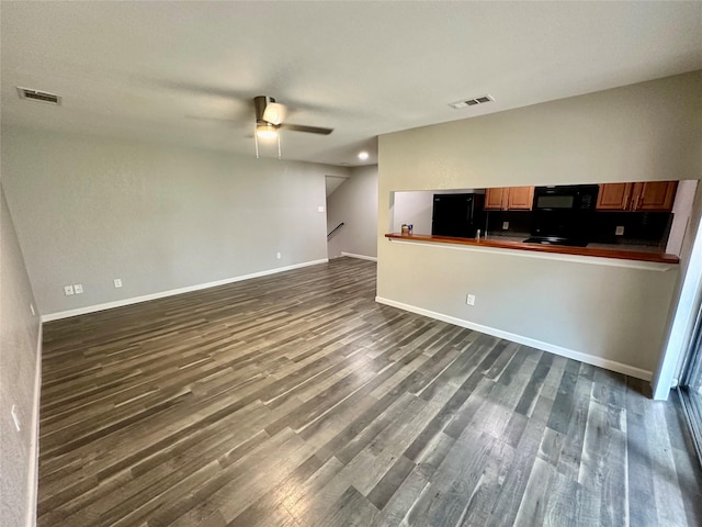 unfurnished living room with ceiling fan and dark wood-type flooring