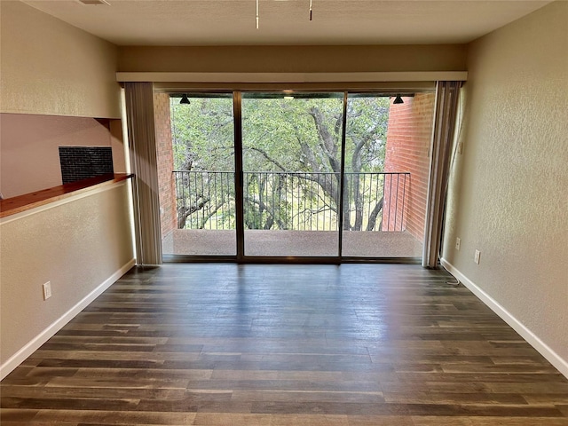 empty room featuring plenty of natural light and dark hardwood / wood-style floors