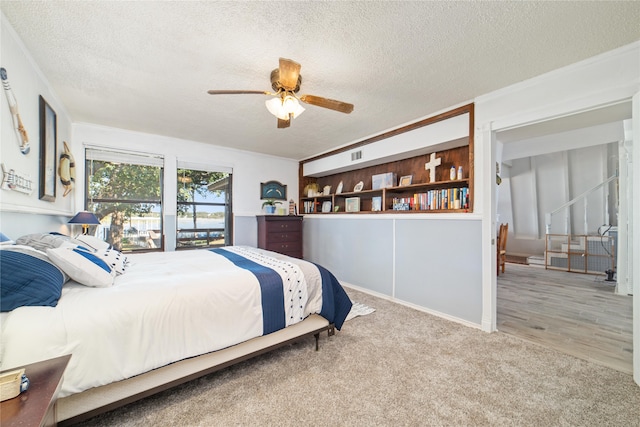 bedroom featuring ceiling fan, light hardwood / wood-style floors, crown molding, and a textured ceiling