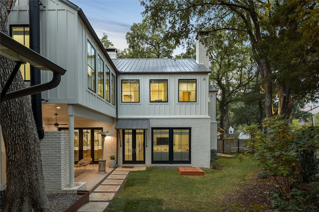 back of house with a patio area and a yard