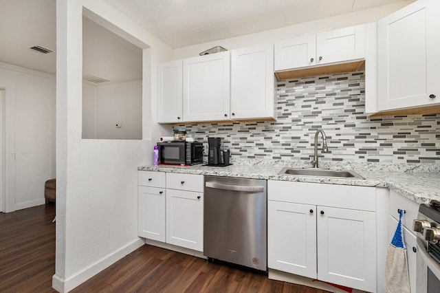 kitchen with tasteful backsplash, sink, white cabinets, and appliances with stainless steel finishes