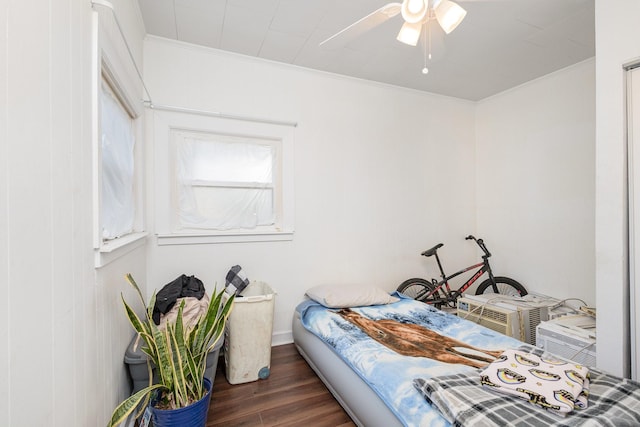 bedroom with crown molding, dark wood-type flooring, and ceiling fan