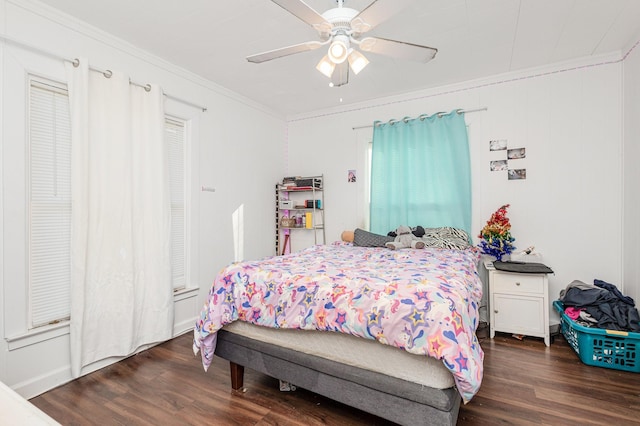 bedroom with ornamental molding, ceiling fan, and dark hardwood / wood-style flooring