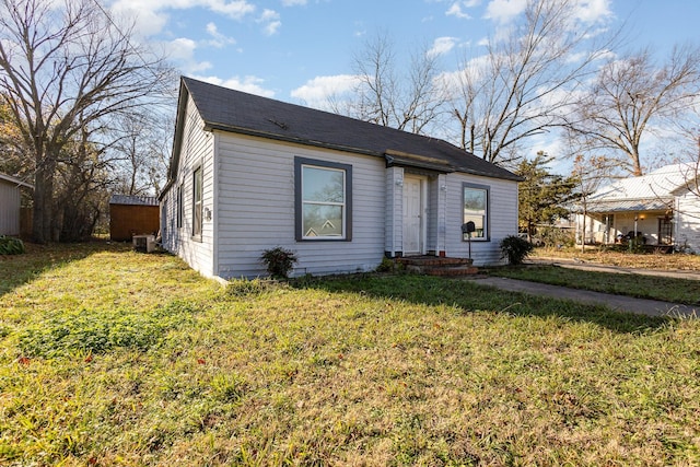 view of front of property with cooling unit and a front yard