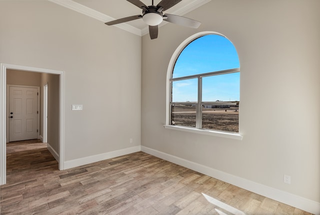 spare room featuring light wood-type flooring, ceiling fan, and crown molding