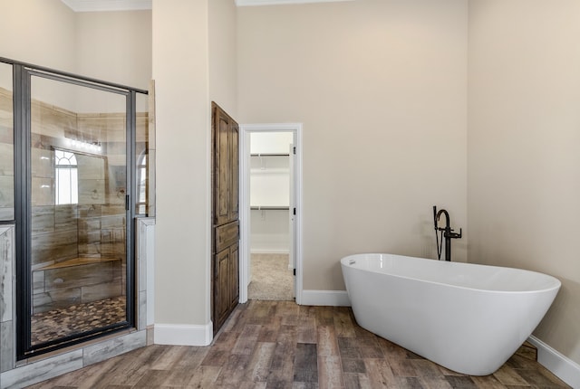 bathroom with wood-type flooring and separate shower and tub