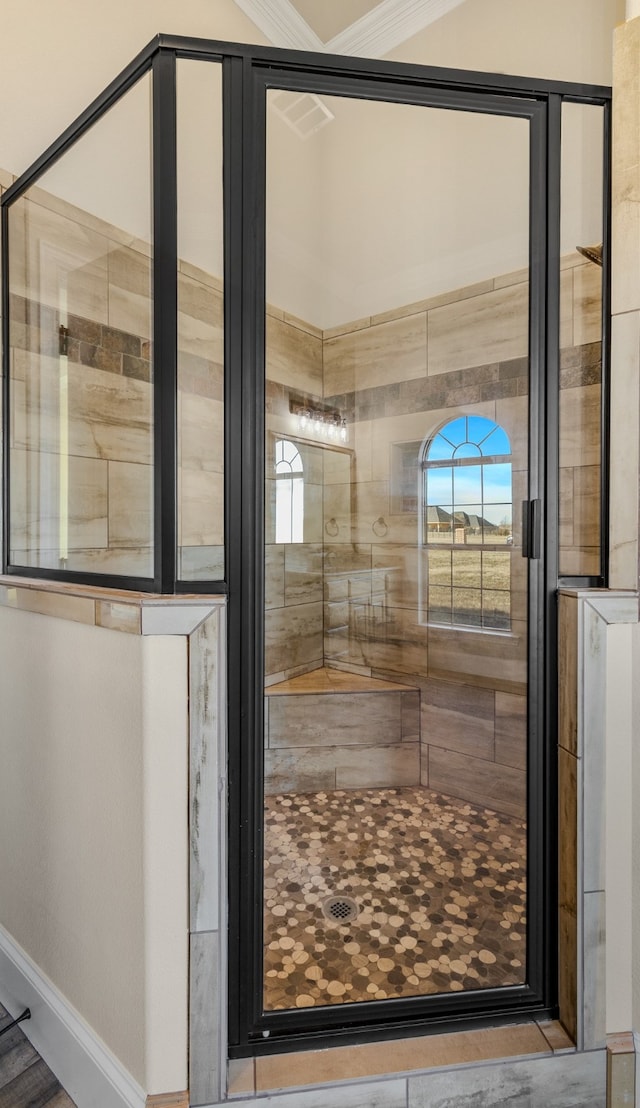 bathroom featuring crown molding and tiled shower