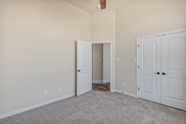 unfurnished bedroom with light colored carpet and a closet