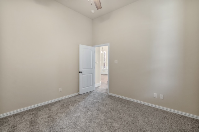 spare room featuring a high ceiling and light carpet