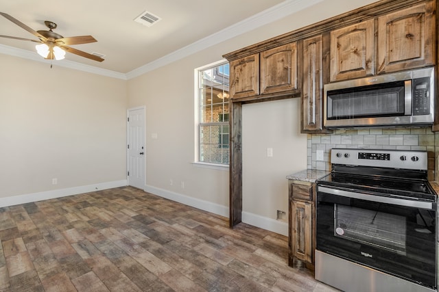 kitchen featuring tasteful backsplash, crown molding, stainless steel appliances, hardwood / wood-style floors, and ceiling fan