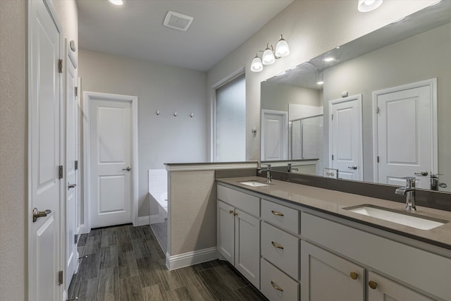 bathroom featuring shower with separate bathtub, hardwood / wood-style flooring, and vanity