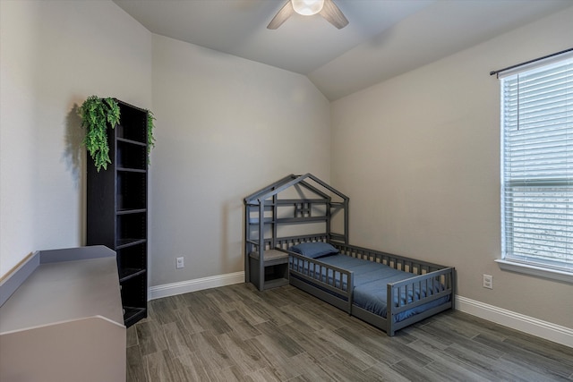 bedroom with multiple windows, hardwood / wood-style floors, and vaulted ceiling