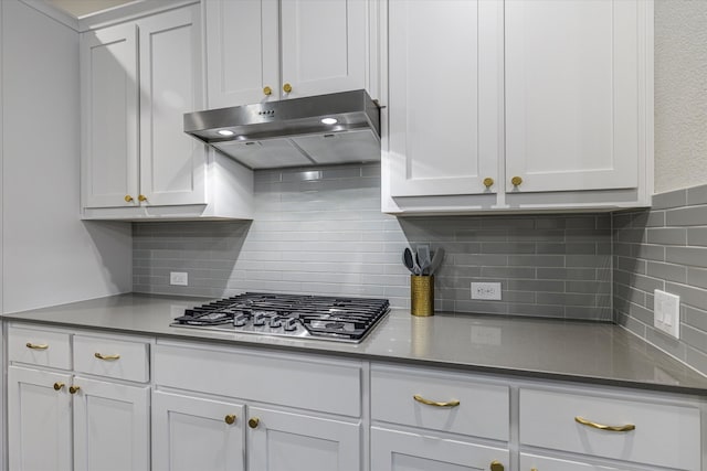 kitchen with extractor fan, stainless steel gas stovetop, tasteful backsplash, and white cabinets