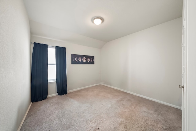 unfurnished room featuring lofted ceiling and carpet floors