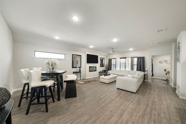 living room featuring a wealth of natural light, ceiling fan, and light hardwood / wood-style flooring