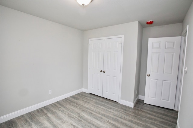 unfurnished bedroom with wood-type flooring and a closet