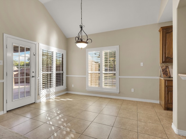 unfurnished dining area featuring high vaulted ceiling, light tile patterned floors, and a healthy amount of sunlight