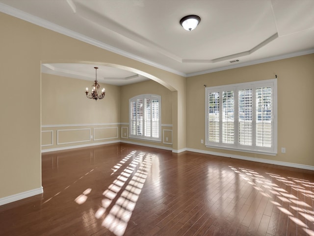 unfurnished room featuring dark wood-type flooring, a chandelier, and a raised ceiling