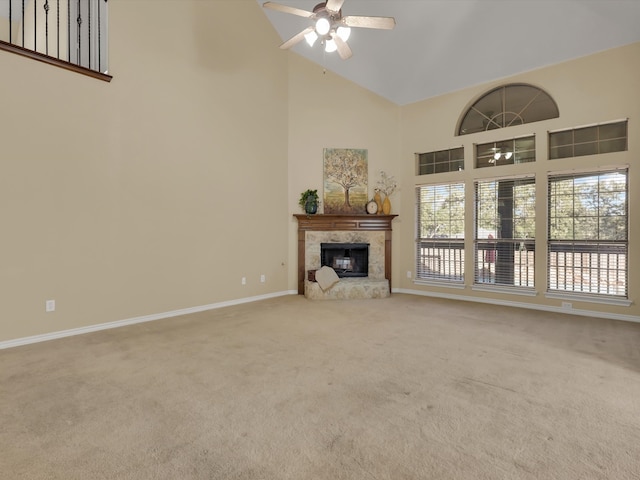 unfurnished living room featuring high vaulted ceiling, a tiled fireplace, light colored carpet, and ceiling fan