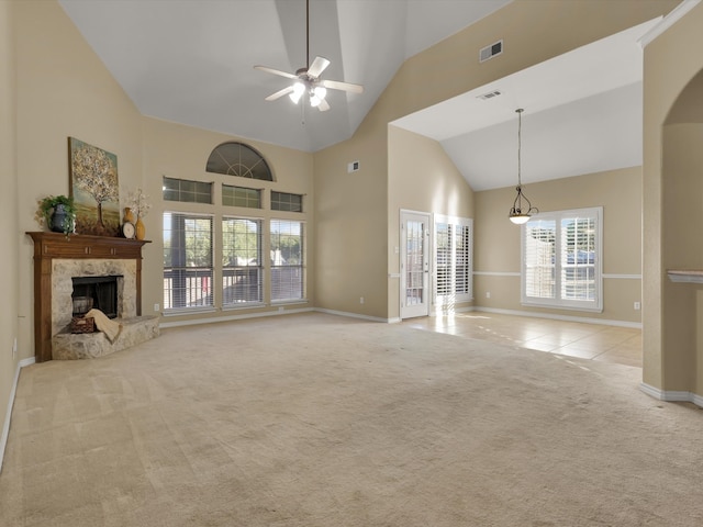 unfurnished living room with high vaulted ceiling, a fireplace, ceiling fan, and light colored carpet