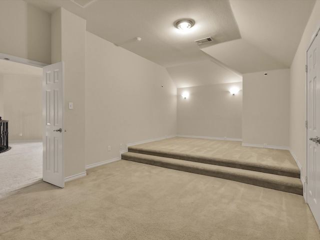 interior space featuring light colored carpet and lofted ceiling